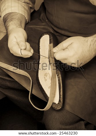 Professional shoe master works instruments with sole of shoe-tree
