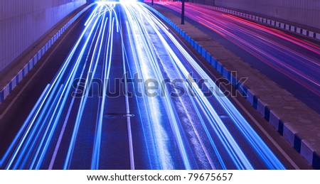 Driving fast lights trails from cars, blue toned