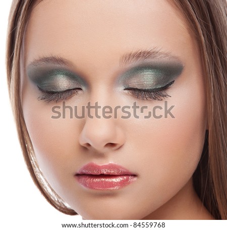 Attractive young woman with modern fashion blue green makeup of female eye on white background