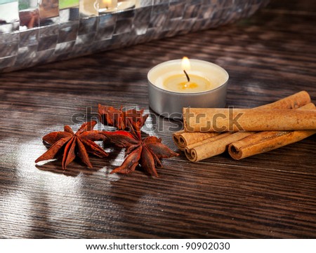 Candle, cinnamon sticks and anise stars on table