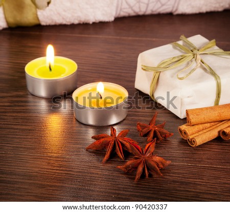 Candle, cinnamon sticks and anise stars with candle on table