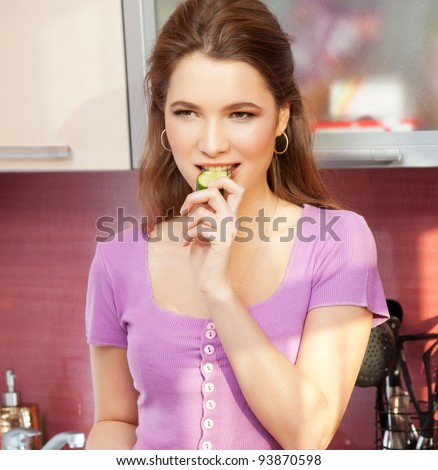 Attractive young woman eating health food smiling and joyful in the modern kitchen