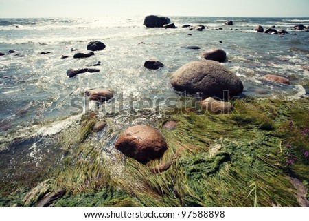 Seaside with rocks waves and blue sky, clean water with fresh clean water and soft wind