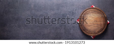 Pizza or bread cutting board and cloth napkin for homemade baking on table. Food recipe concept at stone background texture with copy space. Flat lay of  panorama, panoramic top view