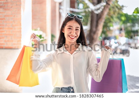 Portrait of Asian girl excited beautiful girl wearing sunglasses happy smiling with holding shopping bags enjoying in shopping relaxed expression, Positive emotions shopping, lifestyle concept.