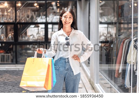 Portrait of Asian girl excited beautiful girl happy smiling with holding shopping bags relaxed expression, Positive emotions shopping, lifestyle concept.