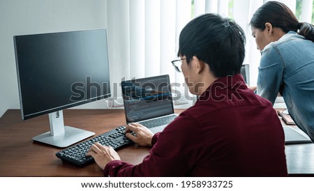 Team of asian programmer looking on multiple screen laptop for brainstorm to programming about new website or application while working together in software development office