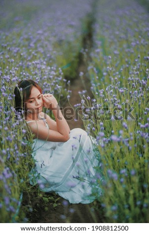 Blond long haired woman in lavender field. Style life enjoying journey to travel on vacation with relaxation with in long white dress outdoors on summer day.