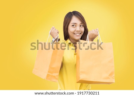 asian girl happy shopping on yellow theme with asian girl model pulling her shopping bag on yellow background (include path)  