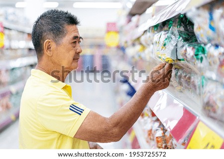 Portrait of asian senior man customer choosing and buying food at the supermarket