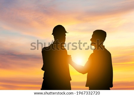Silhouette of Engineer and foreman worker with clipping path soul brother handshake, thumb clasp handshake or homie handshake sunset background