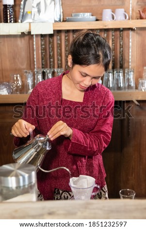 portrait of young woman making drink with teapot