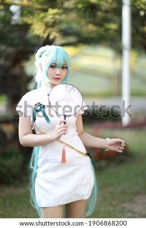Japan anime cosplay portrait of a girl with chinese dress costume in chinese garden