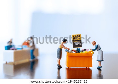 Miniature people , Shoppers with discount tray for shopping discounted items