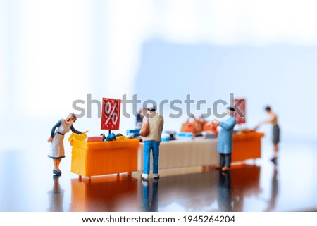 Miniature people , Shoppers with discount tray for shopping discounted items