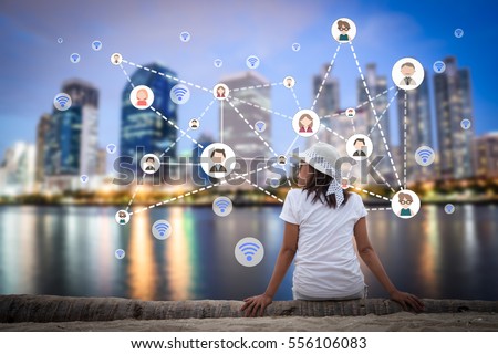 Woman sitting in the city park near the river with people and multimedia icon. Technology networking concept.