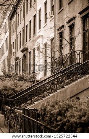 View of apartment buildings and brownstones along pretty street in New York City with sepia tone