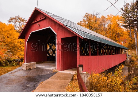 Beautiful Vermont covered bridge surrounded by colorful fall foliage.
