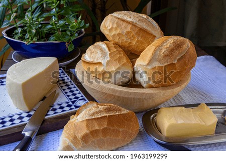 Basket of French bread, traditional Brazilian bread, with cheese and butter for breakfast.