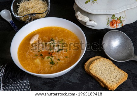Brazilian cuisine - Chicken soup or Canja de galinha in portuguese - Traditional Brazil dishes, soup with chicken and rice served on decorated antique soup bowl from the 19th century