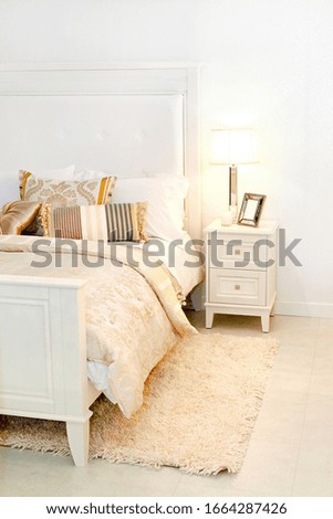 Detail of elegant cozy white bedroom with nightstand
