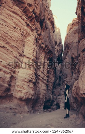 Young woman in black dress in Solomonn Pillars, Timna park, Israel/ Fantasy consept