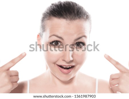 Woman applying concealer under her eyes