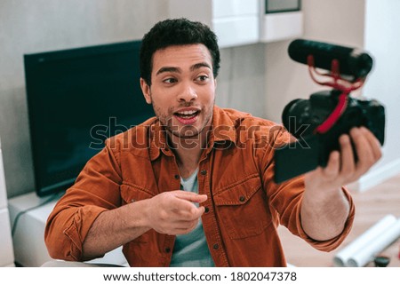 Similar – Image, Stock Photo Young man recording himself while playing guitar and singing to share the video in social media. Musician recording a music video at home.