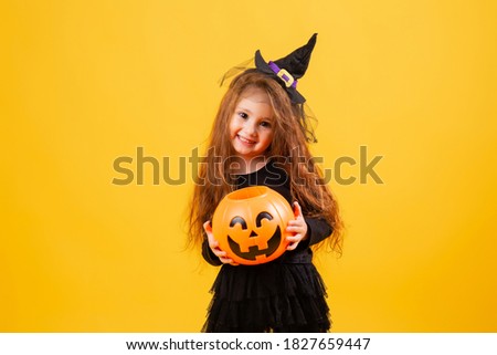 petite fille aux longs cheveux rouges sourit en costume de sorcière d