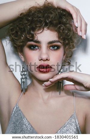Young beautiful woman with curly hair and smoky eye makeup