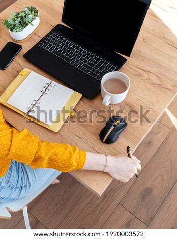 Defocus. Young business woman is resting with a cup of cocoa after work Internet using a computer. Girl has a slow lifestyle near a laptop. Concept a comfort zone in house.