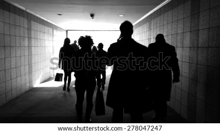 Commuter tunnel, working people walking down tunnel. Abstract workday, business men business women. Walking down urban tunnel, commuters. People in transit.