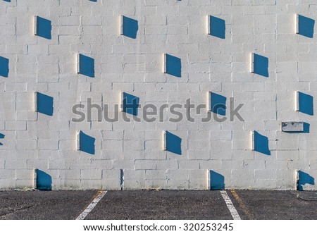 Stucco wall with shadows. Granite wall with studs and shadows. Morning sunlight on exterior wall with shadows. Abstract design. Architecture design and art. Minimal art and design.