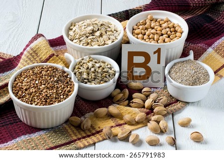 Foods rich in vitamin B1: buckwheat, oatmeal, bran, sunflower seeds, peas, pistachio nuts in a cup on a brown napkin
