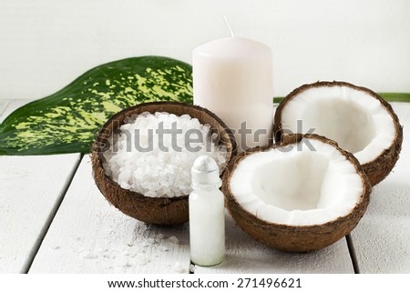 Coconut Spa concept: coconut, coconut oil, sea salt and candle with the scent of coconut on a white background