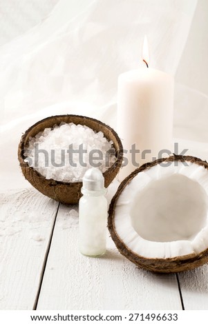 Coconut Spa composition: sea salt, coconut, coconut oil and a candle with the scent of coconut on a white background. Selective focus