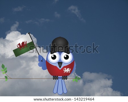 Comical Welsh flag waving bird Patriot sat on a tree branch against a cloudy blue sky
