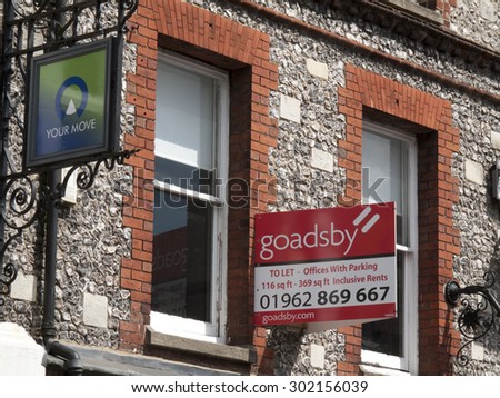 Winchester High Street, Hampshire, England - July 31, 2015: Estate agent to let signs over properties advertising vacant retail premises