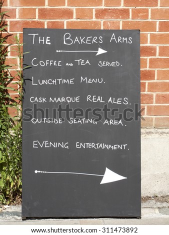 Winchester, High Street, Hampshire, England - July 31, 2015: The Bakers Arms Public House direction sign advertising menu and entertainment
