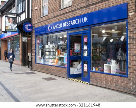 Andover, High Street, Hampshire, England - September 25, 2015: Cancer Research UK retail store, the worlds largest independent cancer research charity, late rain soaked afternoon