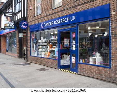 Andover, High Street, Hampshire, England - September 25, 2015: Cancer Research UK retail store, the worlds largest independent cancer research charity, late rain soaked afternoon