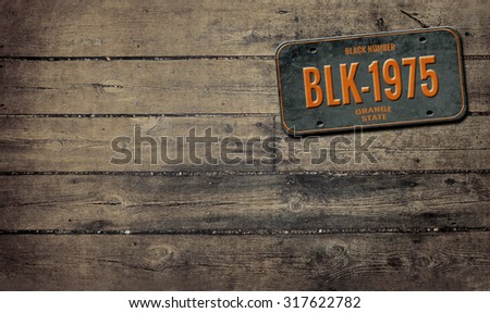 Old plate on wood. Retro background. License plate on wooden background