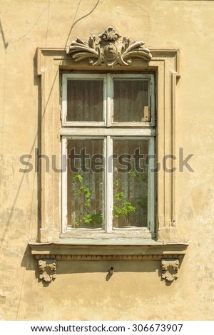 A window in an old house. Authentic wooden window frame. Stucco. Vintage wallpaper