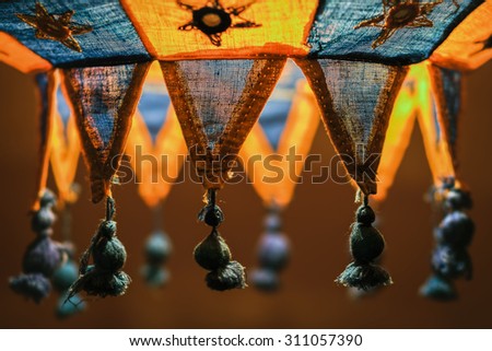 cozy lampshade. woven hand made lampshade close-up. blurry background. relax bedroom wallpaper. warm light. embroidered stars. ethnic ornament