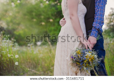 Young healthy couple fashionable girl in a wedding dress guy in a plaid shirt standing with a bouquet of bright flowers in hands, lifestyle, love, wedding