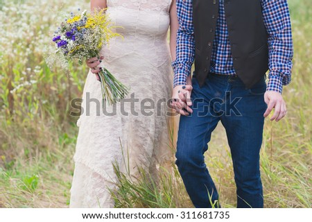 Young healthy couple fashionable girl in a wedding dress guy in a plaid shirt standing with a bouquet of bright flowers in hands, lifestyle, love, wedding