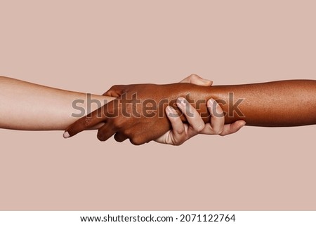 Close up multiracial woman couple with black and caucasian hands holding each other wrist in tolerance unity love and anti racism concept ストックフォト © 