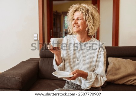 Similar – Foto Bild Lächelnde Frau trinkt Kaffee und benutzt ihr Smartphone auf dem Balkon