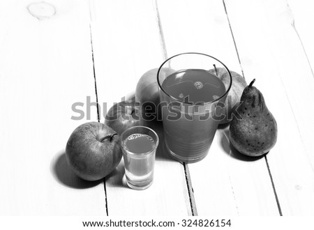 Natural bio apple juice along with a couple of apples on a wooden white board