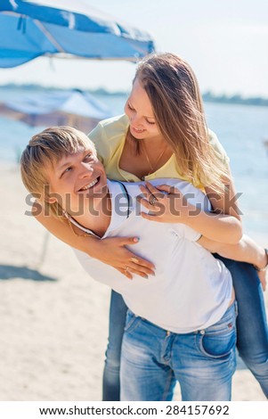 Young couple in love having fun and jumping on the beach. Positive emotions